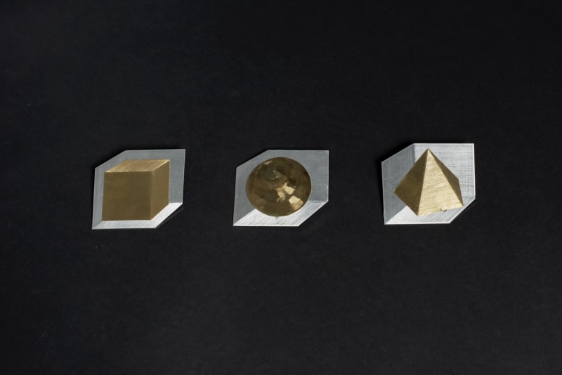 The three brooches look like brass cube, sphere, and triangular pyramid in each silver square space. They looks like 3D but they are 2D.