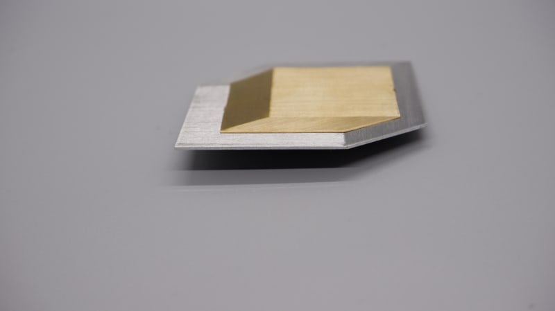 brass cube in a silver square space