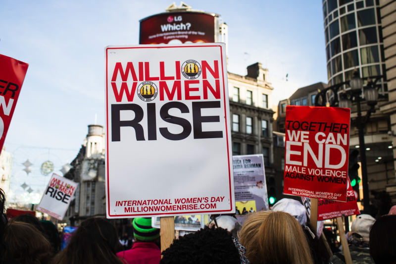  A placard reading: 'Million Women Rise' with a backdrop of Picadilly Circus from the Million Women Rise march