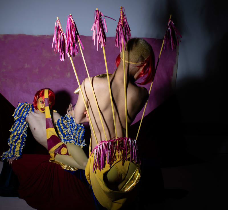 Yellow screen-printed velvet bodysuit with satin-gold lining and thong; handmade, hand-cut & hand-sewn gelatin sequins; balloon textile; wood sticks