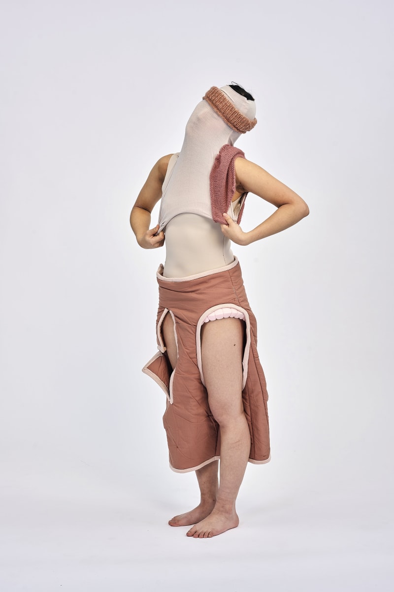 Model putting on final garment top