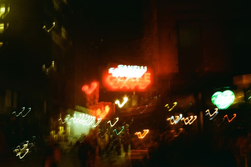 Blurry nighttime photos of the city street with neon signs.