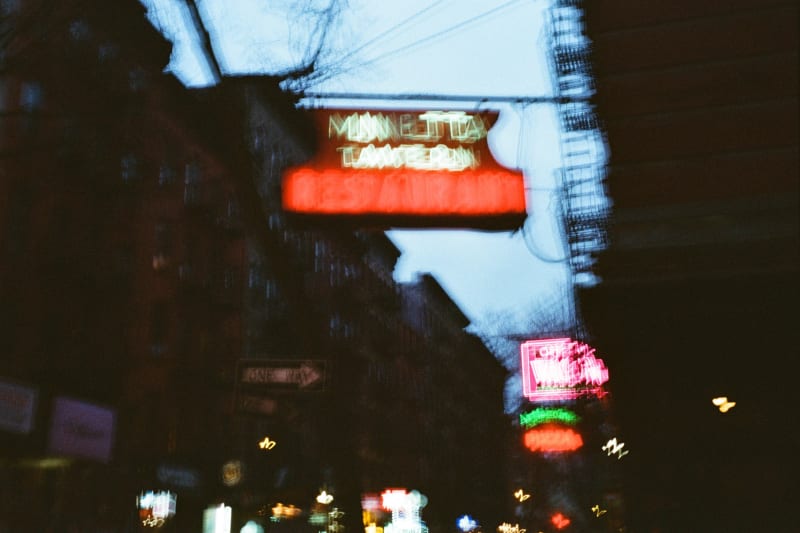 Blurry nighttime photos of the city street with neon signs