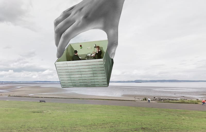Office cubicles lifted from Playtime and placed onto a natural beach landscape.