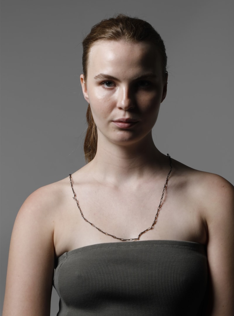 long chain necklace made out of needle eyes. blackened.