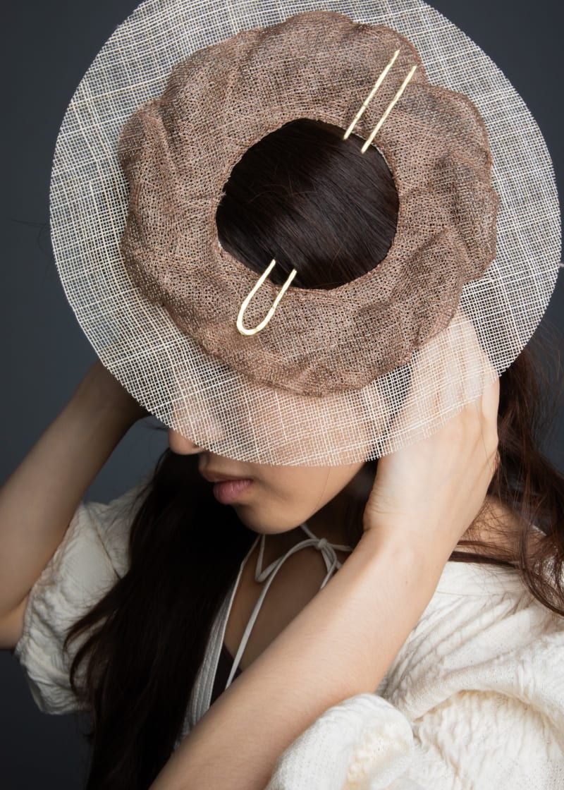 This work softly reinterprets the gache–gat fusion, with a circular braid framed by a sheer brim, balancing tradition and elegance.