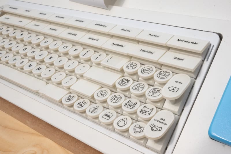 Below the seesaw is a retro-style white keyboard and a small thermal printer, which has printed a narrow receipt.