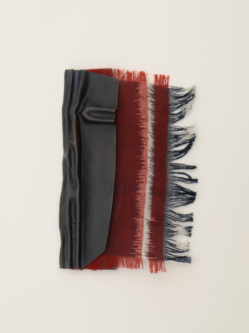 dark brown patinated brooch with fold forming technique, incorporated with traditional Indonesian textile