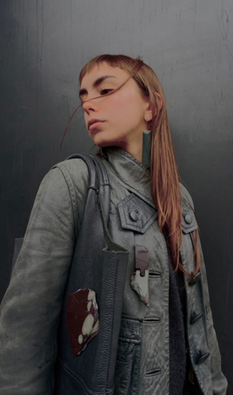 A woman wearing slate earrings, and 2 slate brooches. 