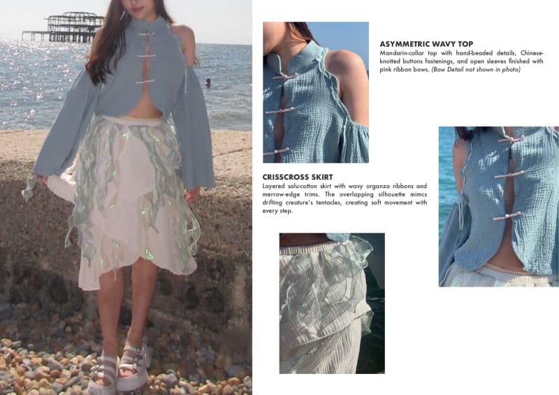 Model posing a a blue asymmetrical top with a sheer layered skirt, standing at the shore edge with detailed description.
