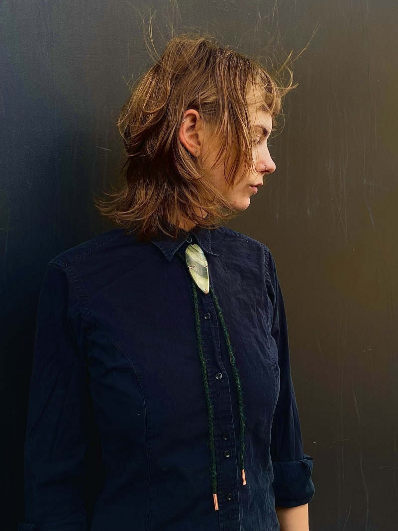 a woman wearing the slate and copper bolo tie. 