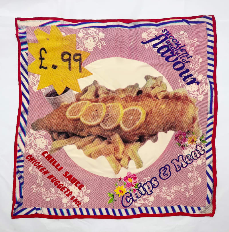 flat lay photo of silk scarf with fish and chips in the middle. Pinks blue and yellows. 