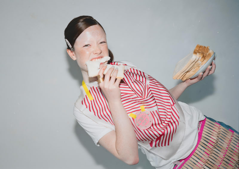 model eating bread wearing striped screen printed sample in a studio setting