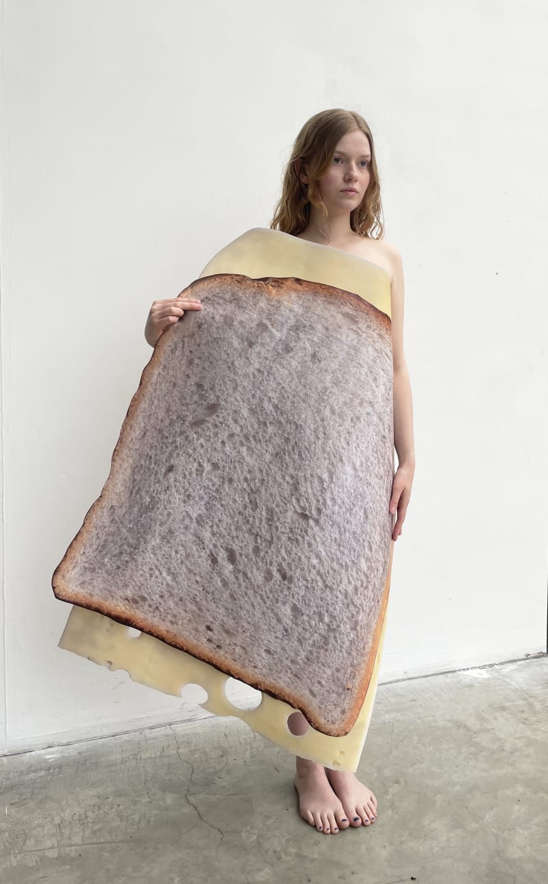 model holding giant paper bread and cheese
