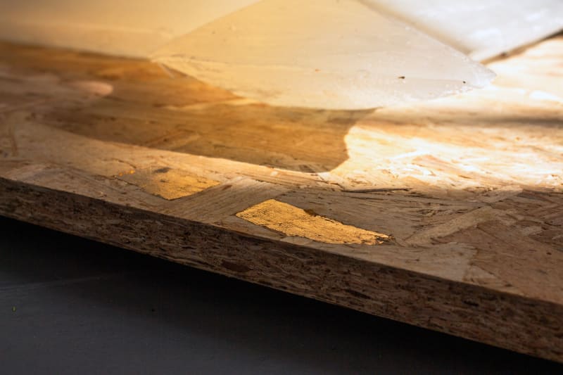 close up of shadows & gold leaf on a sheet of OSB