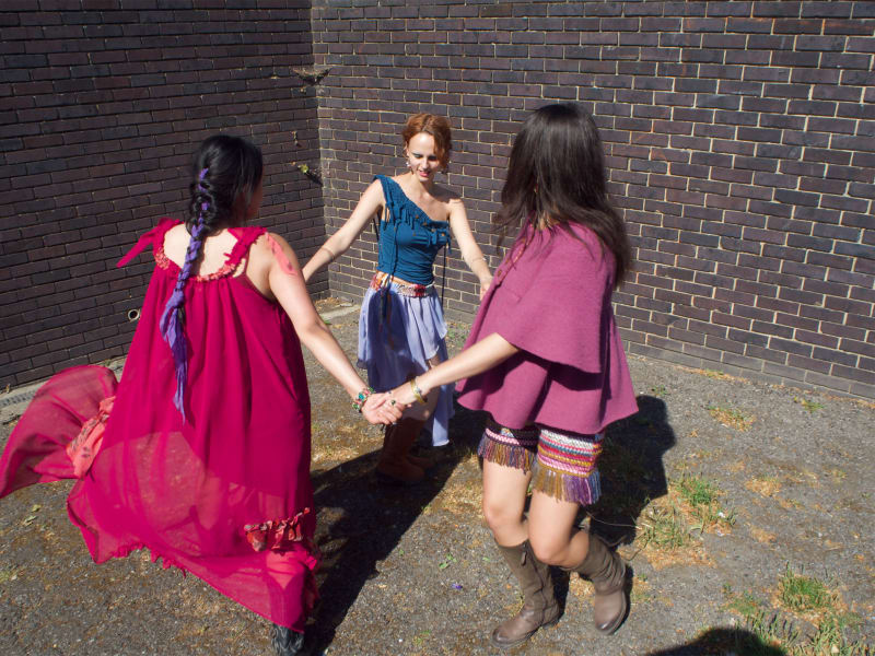 Group of models holding hands and dancing.