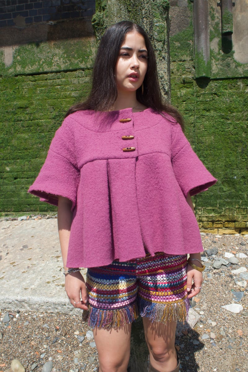 Model wearing mauve coloured wool jacket and woven shorts from up-cycled fabric scraps.