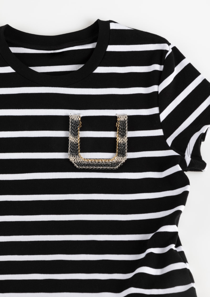 A patch pocket–shaped brooch that mimics the pattern of women's striped T-shirts.