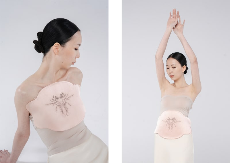 A pale pink silk vest embroidered with a narcissus flower in human hair.
