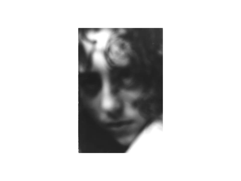 Blurred, close-up black and white portrait of a young woman's face.