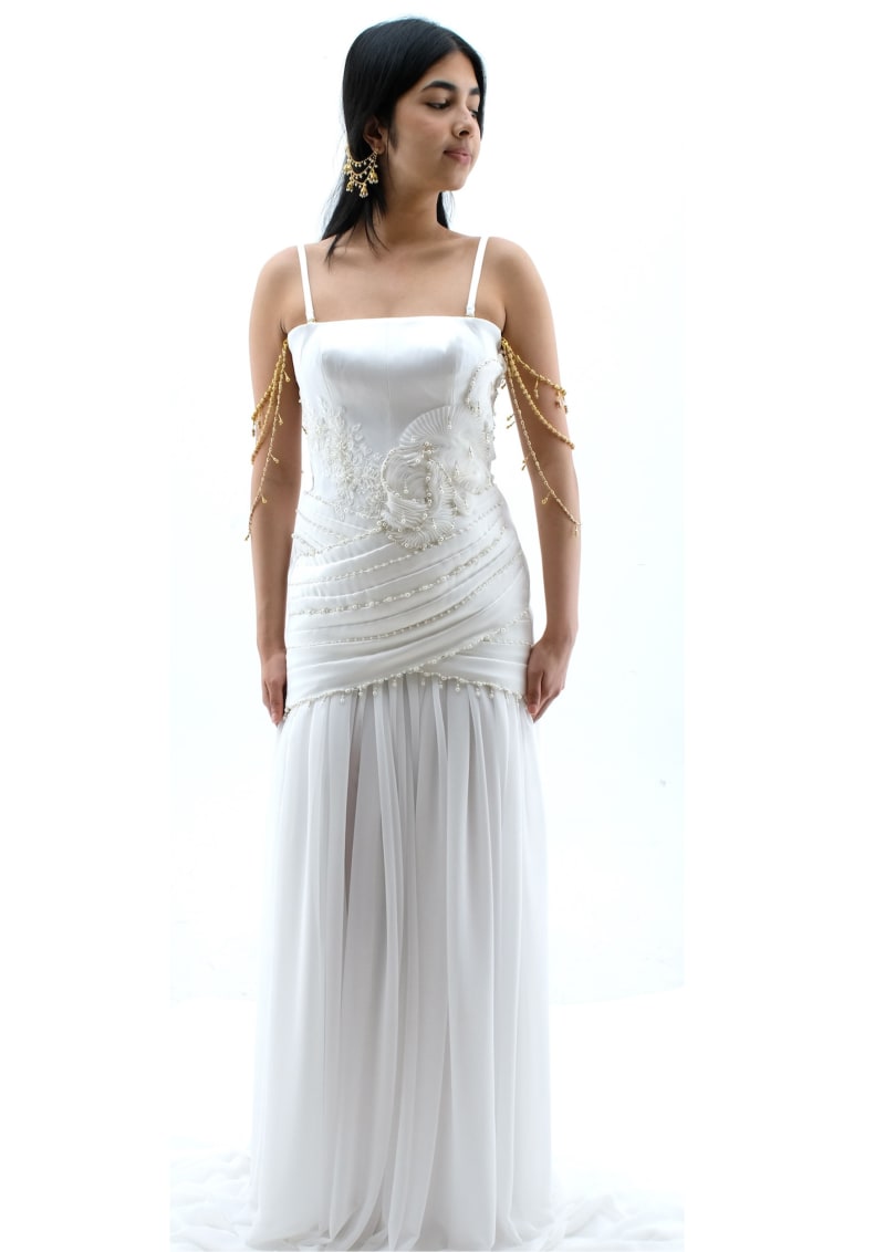 Highly embellished white satin gown with detachable beading and loops paired with white chiffon gathered underskirt.