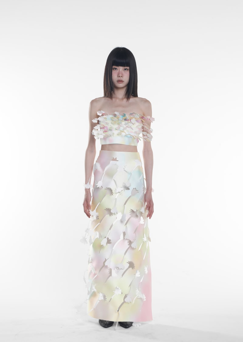 A woman wearing a lasercutting flower fringe top and skirt