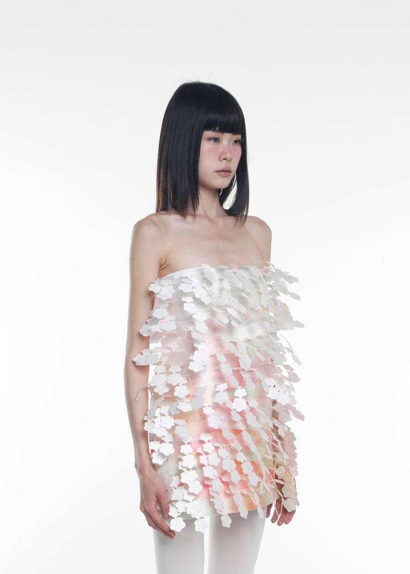 Model wearing a white pink laser cut dress