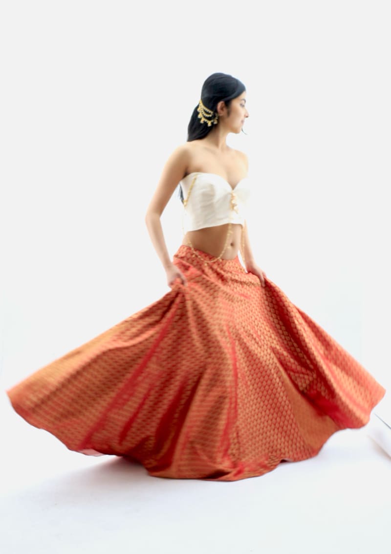 V-neck strapless blouse with detachable beading and loops paired with lehenga skirt with godets.