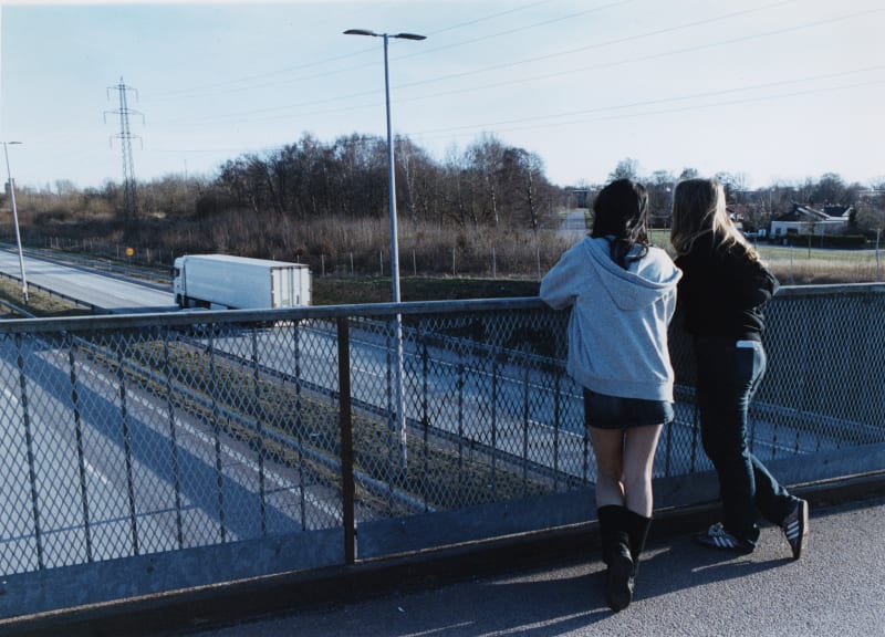 The photograph shows the two friends looking out from a bridge.