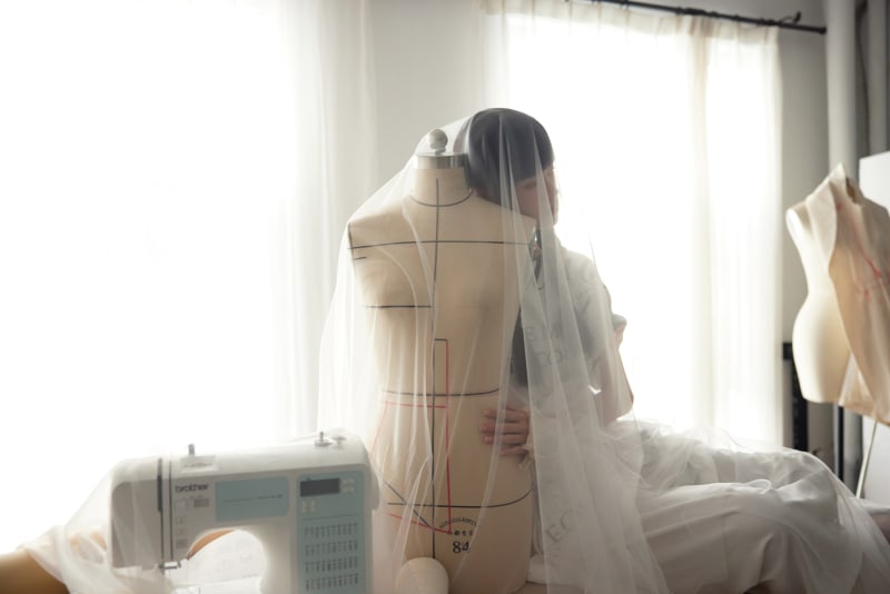 The designer with dummy and fabric in soft studio light
