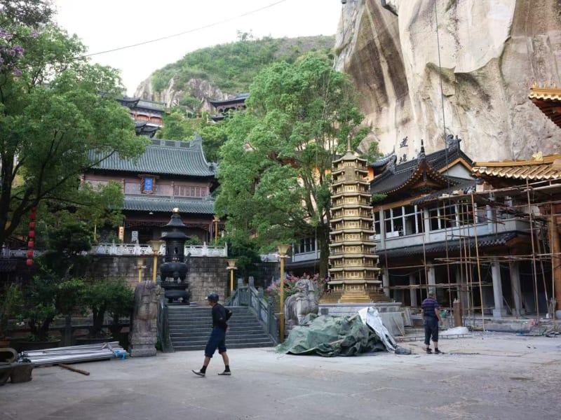 Buddhist temple and monument in a mountainous area showing the construction work to preserve the structures.