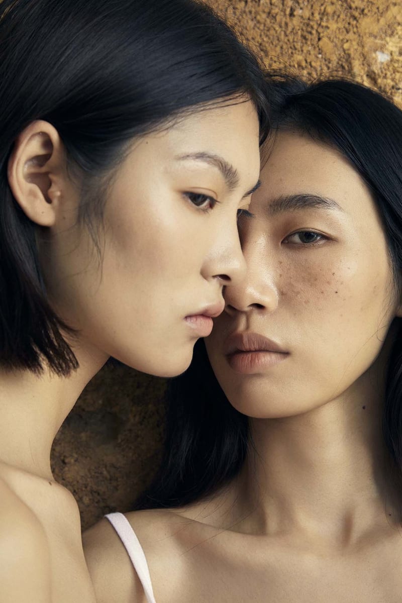 Two faces meet in near silence, their skin almost touching; a quiet confrontation of longing, reflection, and recognition.