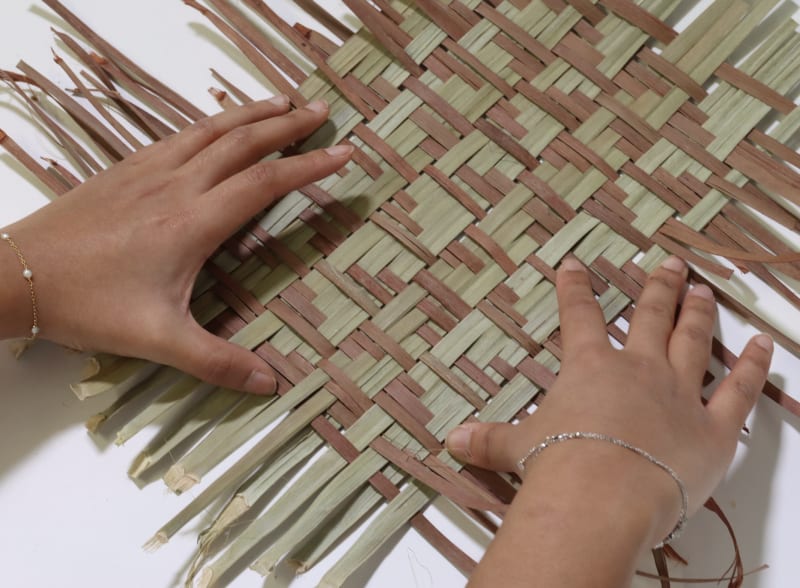 Weaving palm leaves.