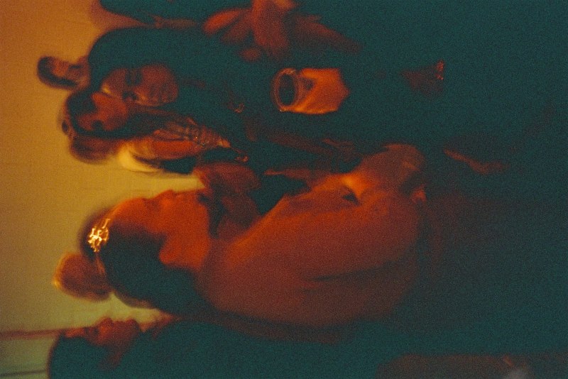 a series of red/orange toned photographs featuring people dancing and large circular speakers