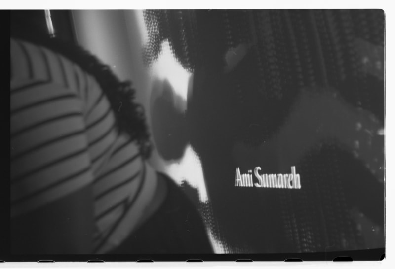 black and white image with the name "Ami Sumareh" projected on a screen.