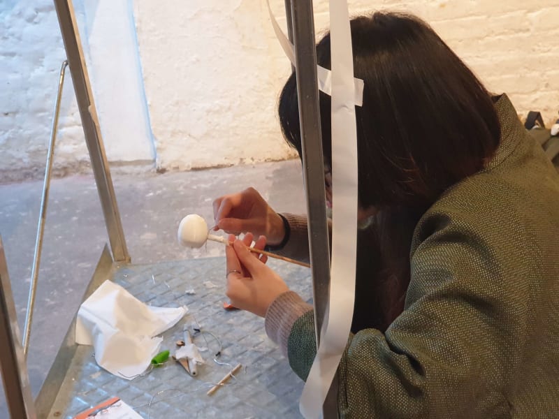 A person gluing a 3D printed head to make a figurine