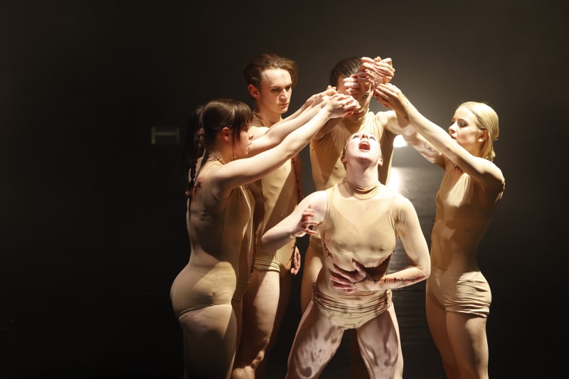 Six dancers holding the candles in the dark.