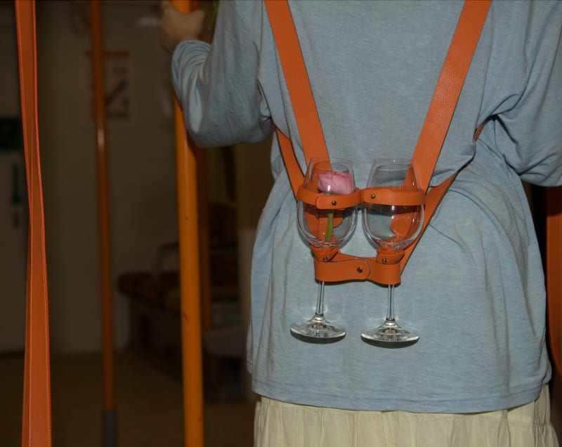 A pair of portable wine glasses designed for hosting gatherings, which can be transformed into hanging straps in overground carriages.