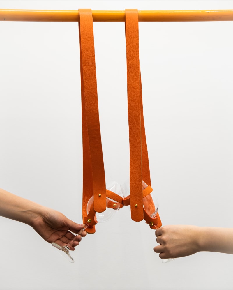 A pair of portable wine glasses designed for hosting gatherings, which can be transformed into hanging straps in overground carriages.