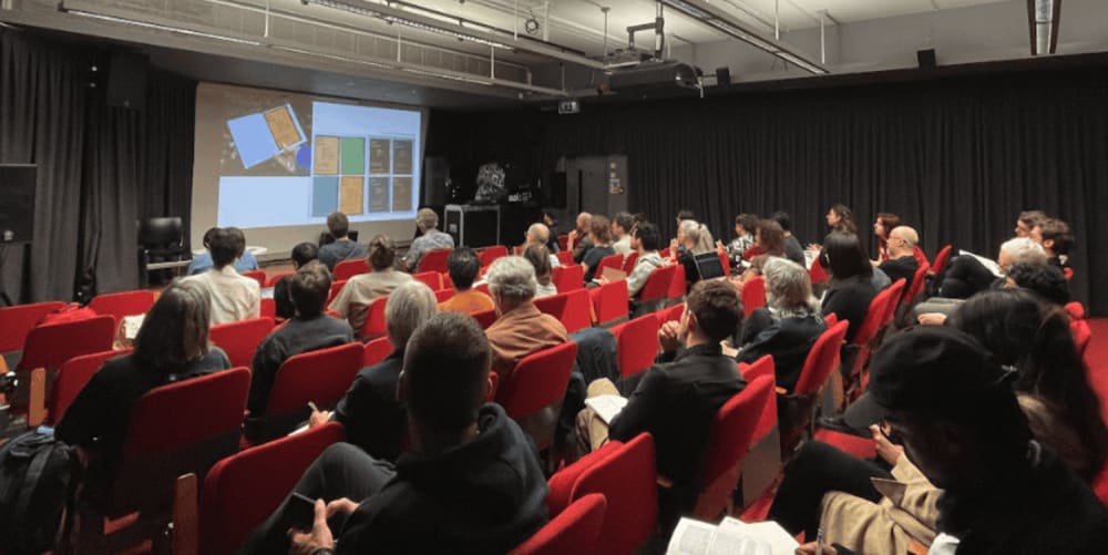 Audience in a lecture theatre listen to a presentation.