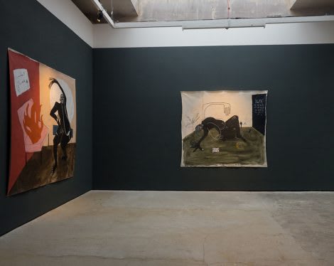 Gallery view of two paintings hanging on a dark blue wall.
