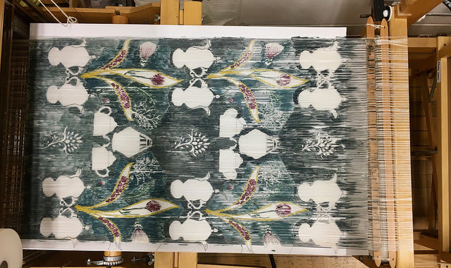 Fabric weaving floral and teapot patterns.