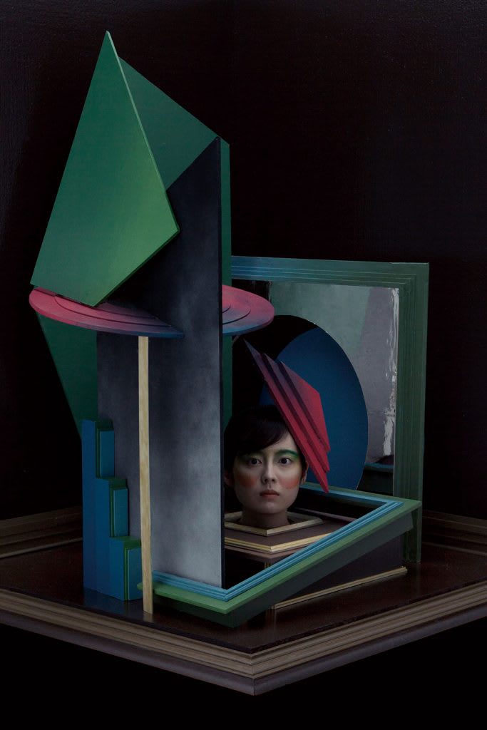 A woman's head surrounded by colourful sculptures. 