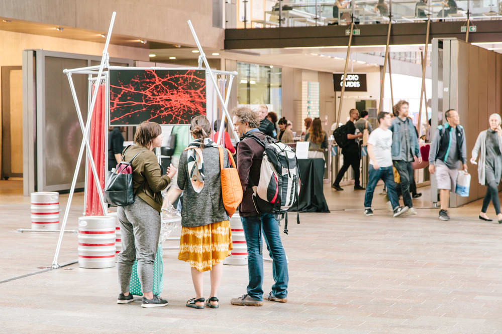 Three people talking in front of an installation at a Degree Show