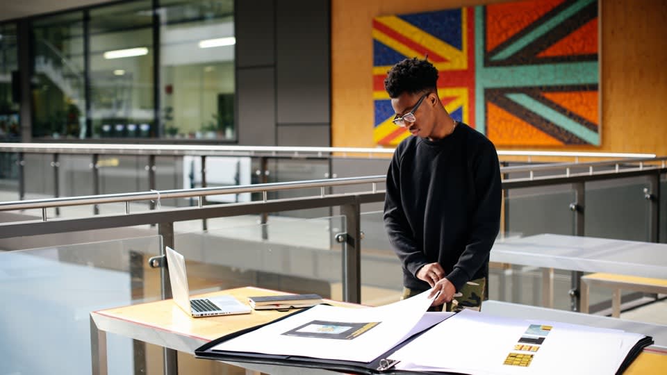Student looking through large portfolio on a table