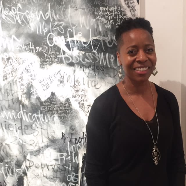 Linett Kamala in front of a black and white painting named 'Courage'