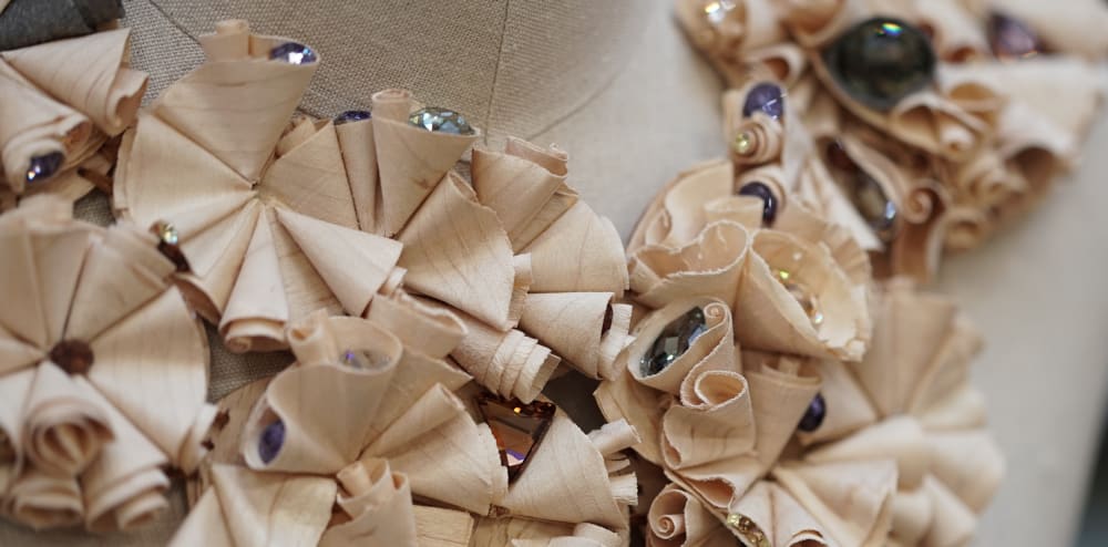 Sustainable neckpiece created from wood shavings and repurposed Swarovski crystals