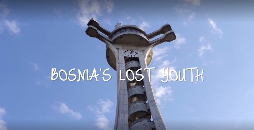 A still from a film of a building shot against a blue sky.