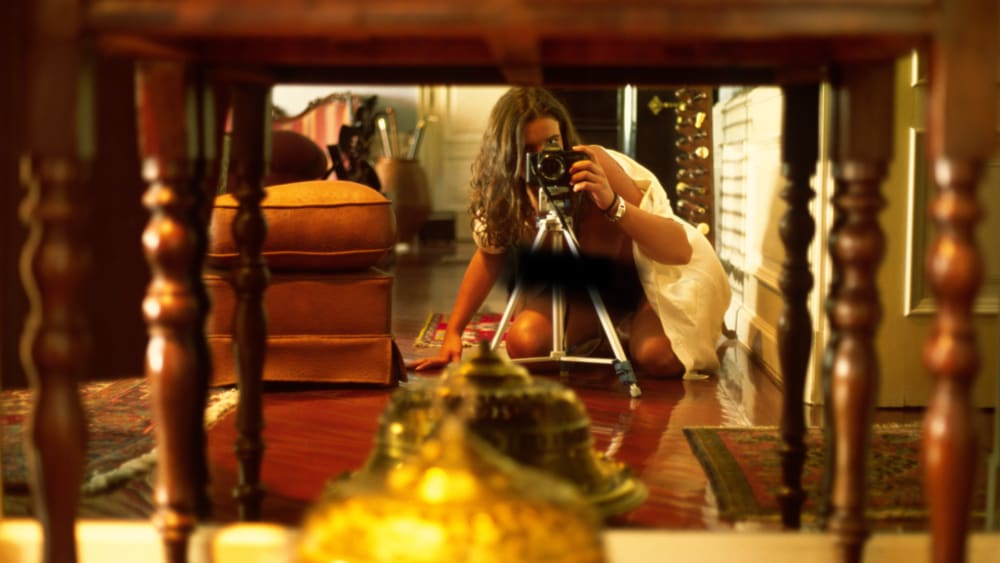 Woman taking picture with camera reflecting off mirror