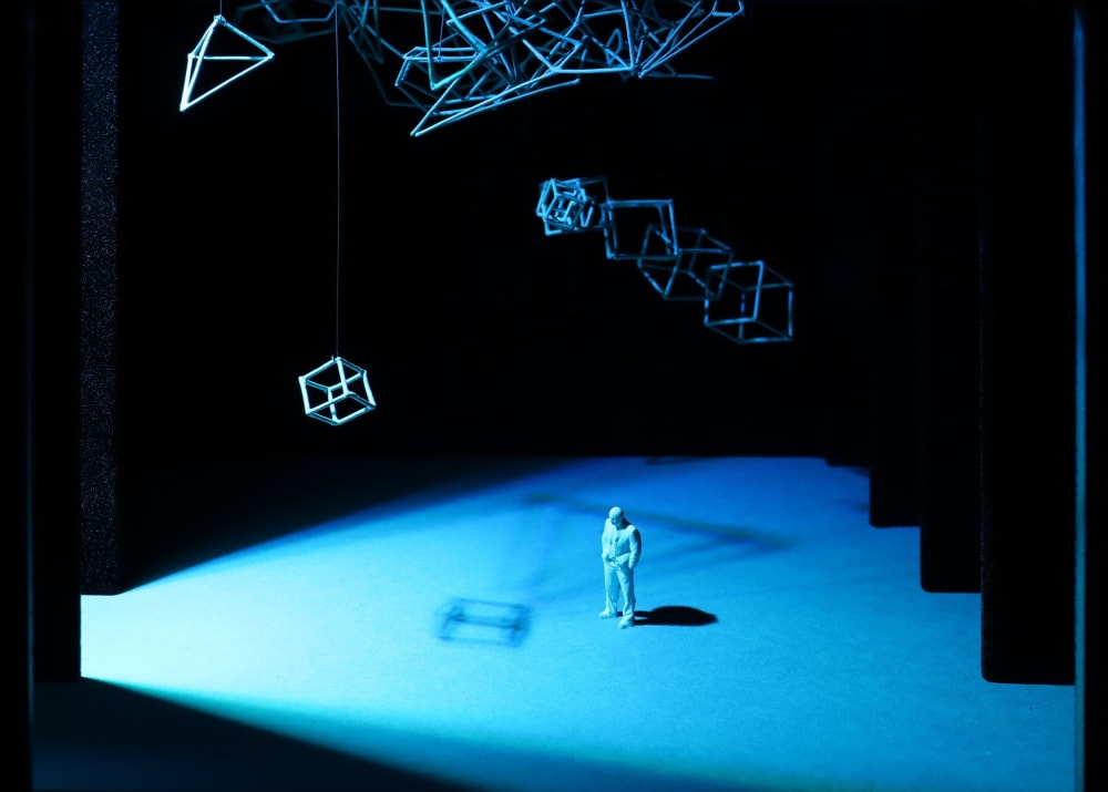 architectural sculpture with steps and figure lit up in colours